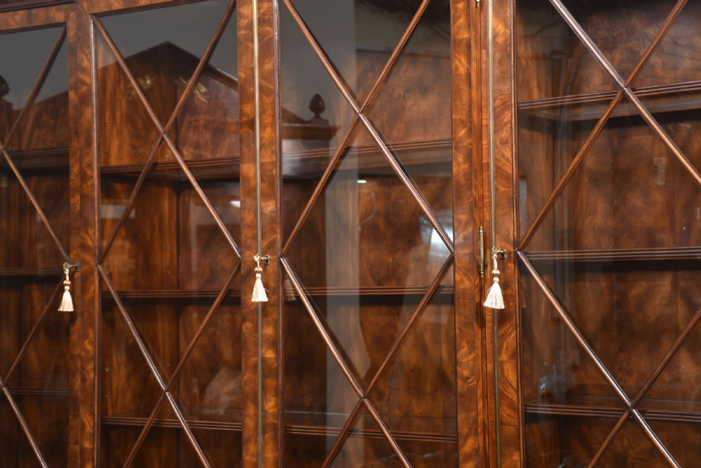 A large George III style mahogany breakfront library bookcase featuring glazed upper doors with astragal bars and a lower base with drawers and panelled cupboards. View XXIV