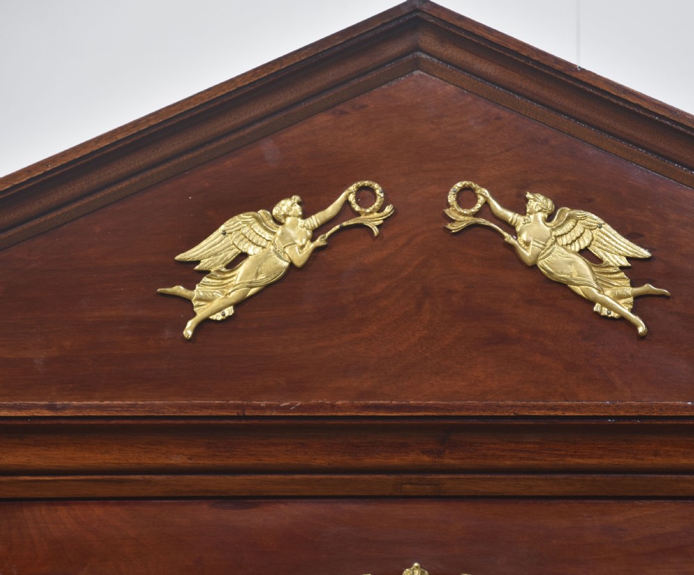 An Empire style mahogany wardrobe featuring twin mirrored doors, a classical pediment cornice, brass lion-ring drawer pulls, and gilt bronze mounts. View VII