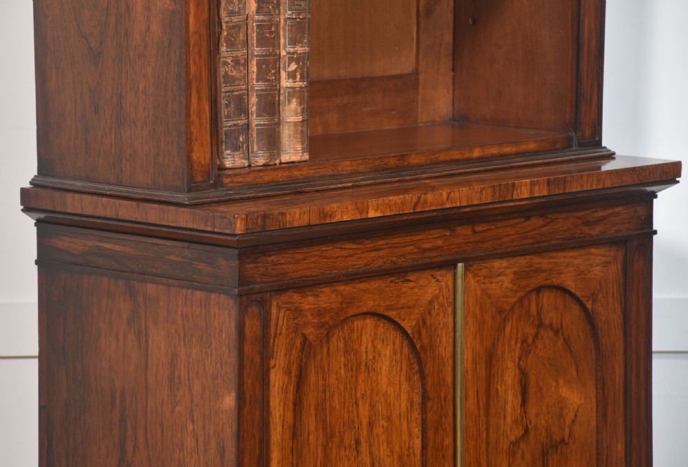 A tall 19th-century rosewood open bookcase with three upper shelves above a lower cabinet featuring two arched panel doors. View XII