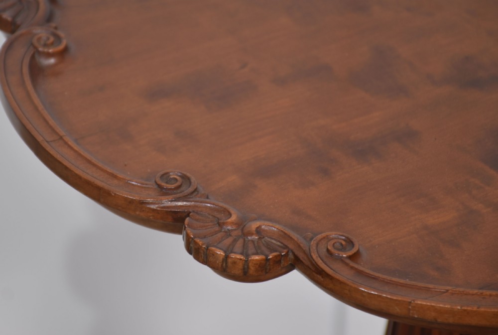 A George III satinwood tripod table with a piecrust rim resting on a fluted column and three carved cabriole legs. View VI