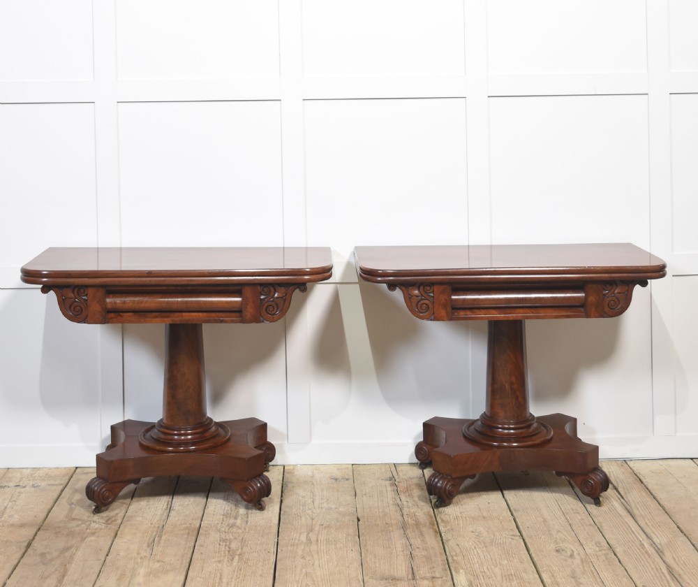 A pair of Regency mahogany fold-top tea tables resting on central cylindrical pedestals with quadruped scroll-foot bases. View II