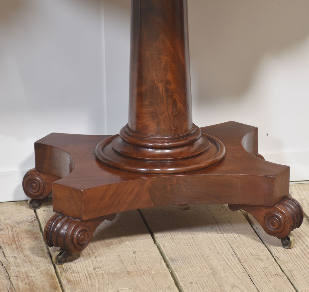 A pair of Regency mahogany fold-top tea tables resting on central cylindrical pedestals with quadruped scroll-foot bases. View III