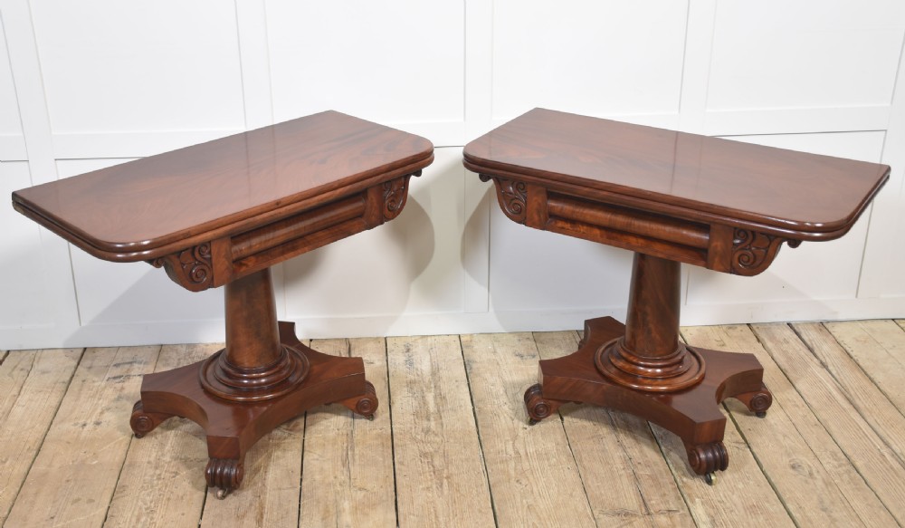 A pair of Regency mahogany fold-top tea tables resting on central cylindrical pedestals with quadruped scroll-foot bases. View IX