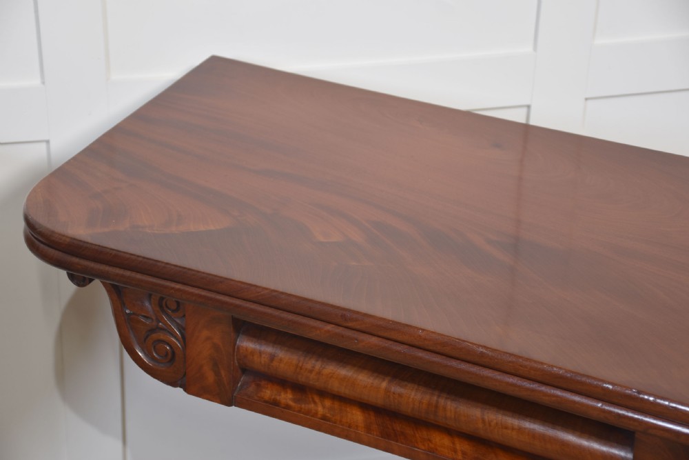 A pair of Regency mahogany fold-top tea tables resting on central cylindrical pedestals with quadruped scroll-foot bases. View X