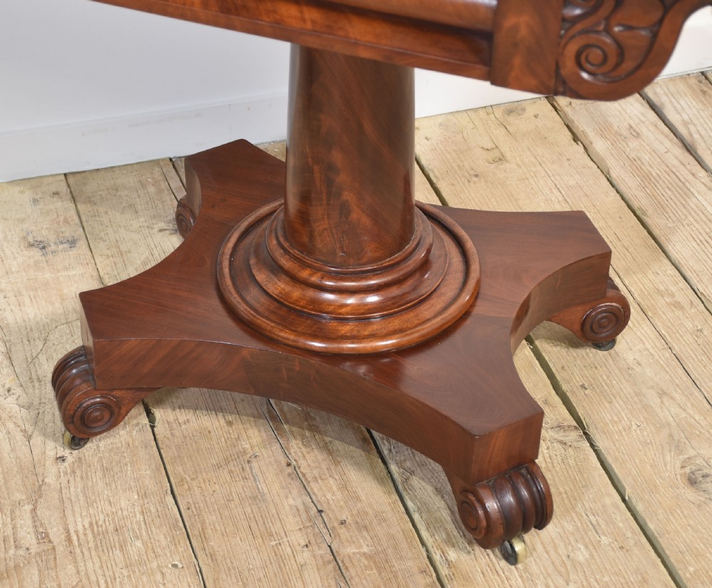 A pair of Regency mahogany fold-top tea tables resting on central cylindrical pedestals with quadruped scroll-foot bases. View XI