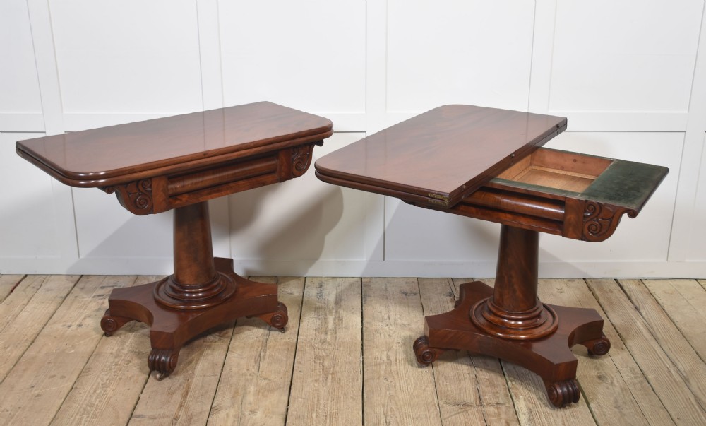 A pair of Regency mahogany fold-top tea tables resting on central cylindrical pedestals with quadruped scroll-foot bases. View XII