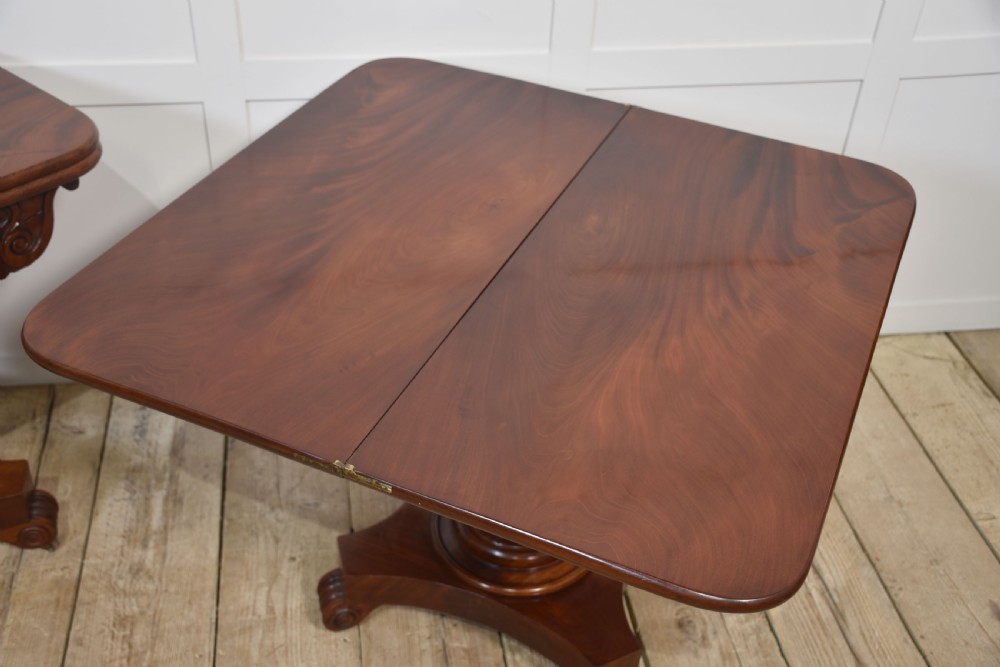 A pair of Regency mahogany fold-top tea tables resting on central cylindrical pedestals with quadruped scroll-foot bases. View XIV