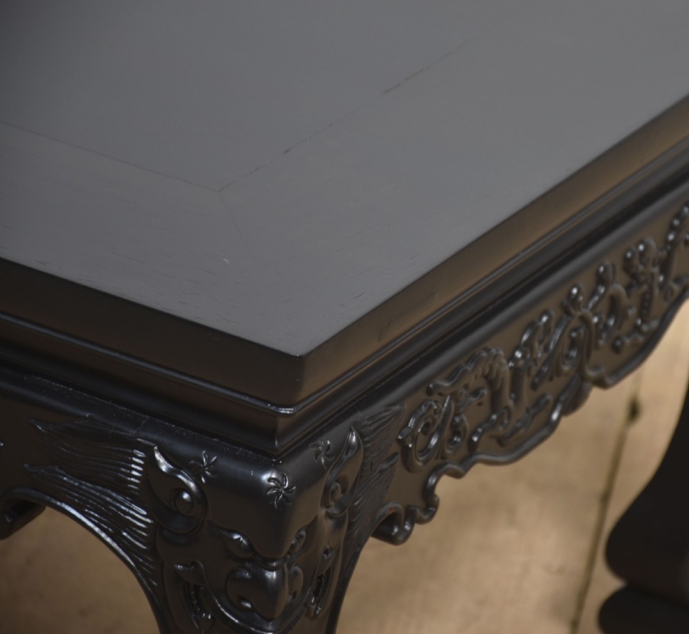 A low rectangular ebonised black wood coffee table featuring intricately carved aprons and shaped cabriole legs. View III