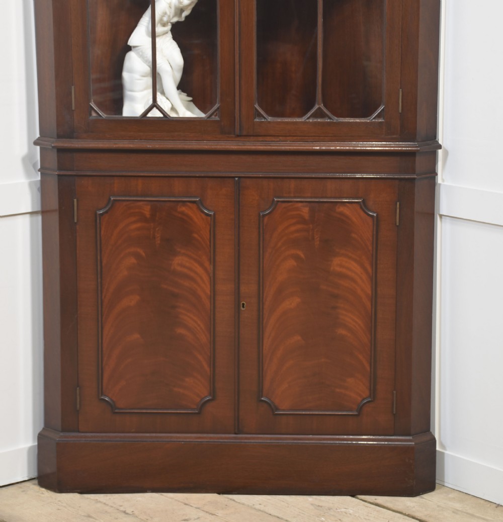 A tall two-tier mahogany corner cabinet featuring astragal glazed upper doors and flame mahogany veneered lower doors. View II