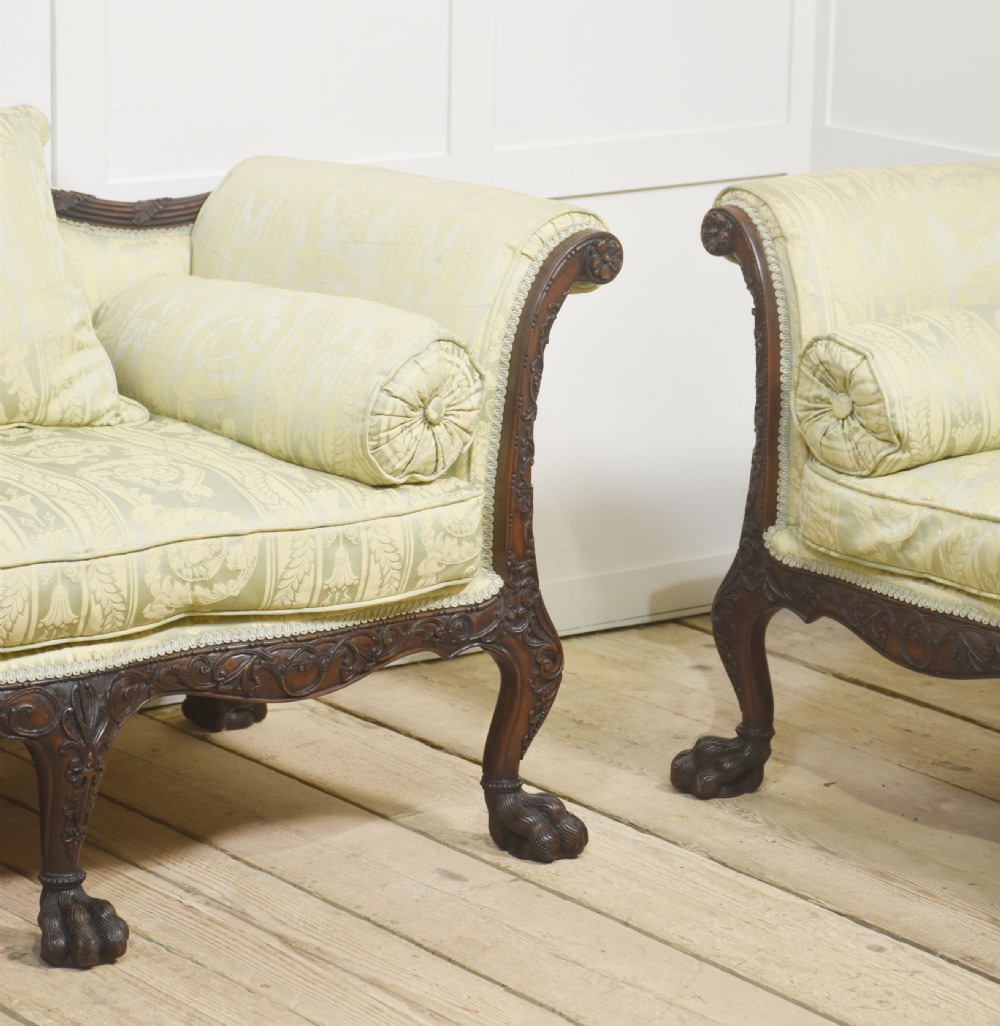 A pair of carved dark mahogany Chippendale revival settees upholstered in light sage patterned fabric with ball-and-claw feet. View II