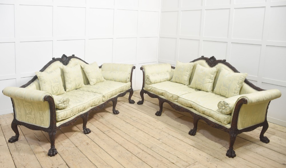 A pair of carved dark mahogany Chippendale revival settees upholstered in light sage patterned fabric with ball-and-claw feet. View VII