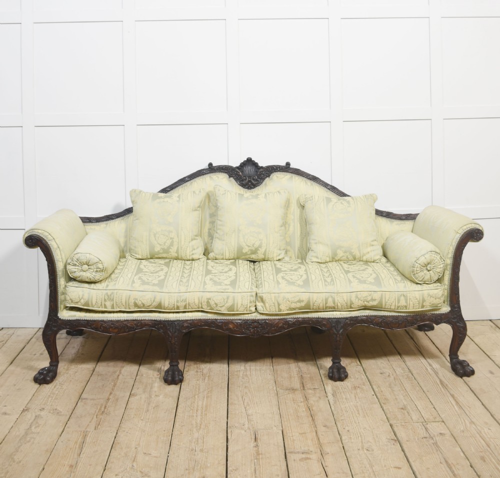A pair of carved dark mahogany Chippendale revival settees upholstered in light sage patterned fabric with ball-and-claw feet. View VIII