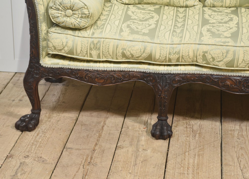 A pair of carved dark mahogany Chippendale revival settees upholstered in light sage patterned fabric with ball-and-claw feet. View IX