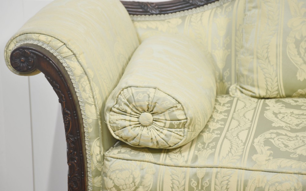 A pair of carved dark mahogany Chippendale revival settees upholstered in light sage patterned fabric with ball-and-claw feet. View X