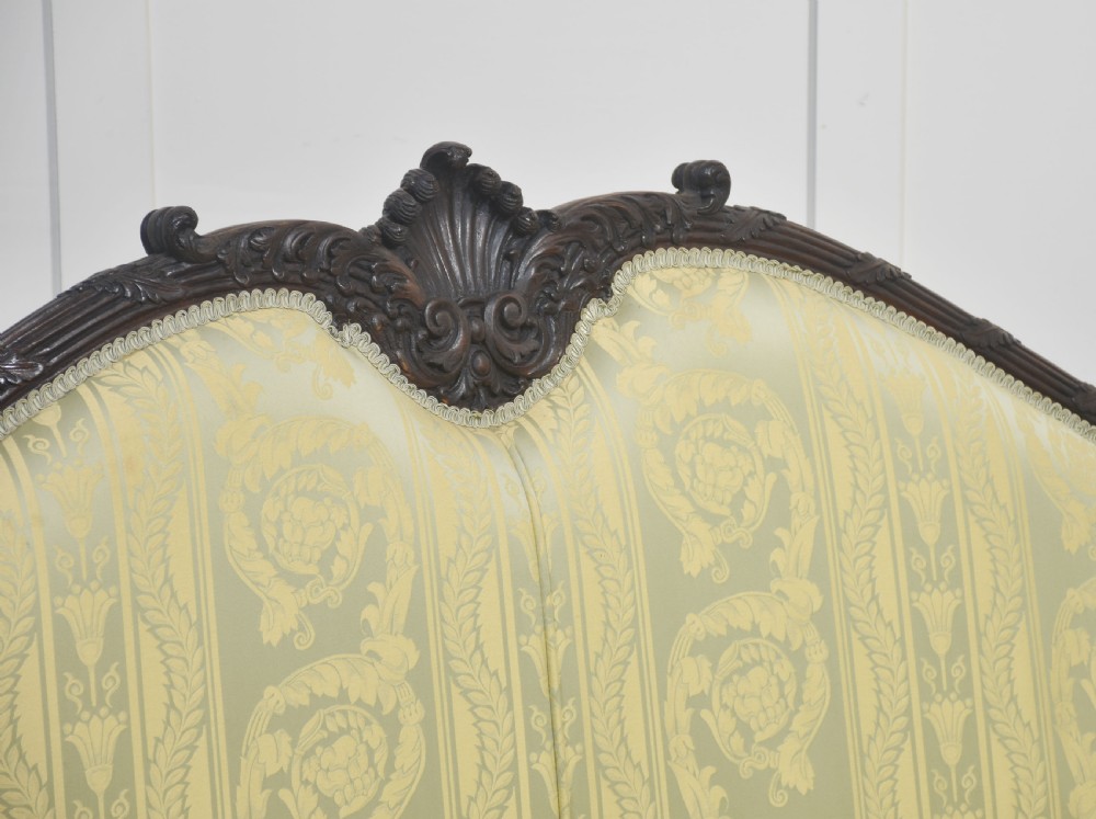 A pair of carved dark mahogany Chippendale revival settees upholstered in light sage patterned fabric with ball-and-claw feet. View XV