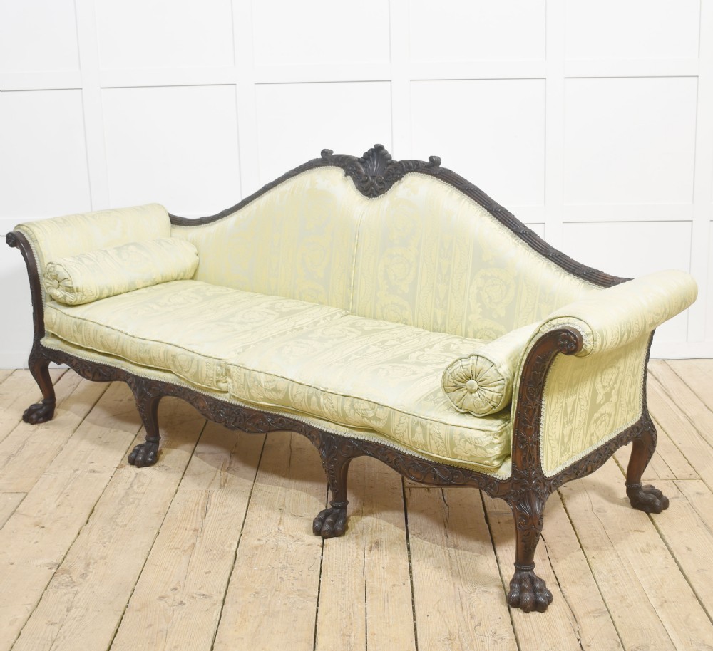 A pair of carved dark mahogany Chippendale revival settees upholstered in light sage patterned fabric with ball-and-claw feet. View XVII