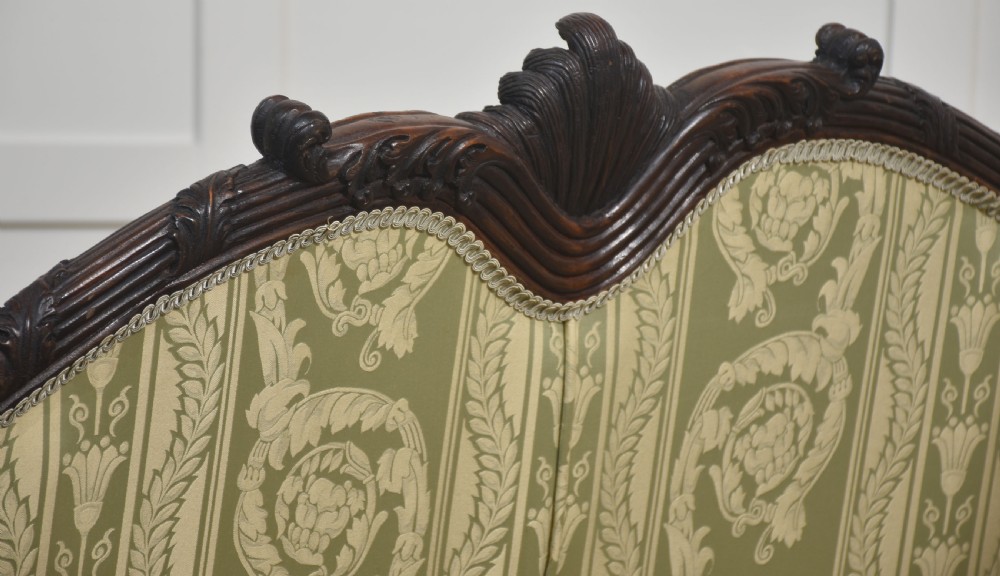 A pair of carved dark mahogany Chippendale revival settees upholstered in light sage patterned fabric with ball-and-claw feet. View XX