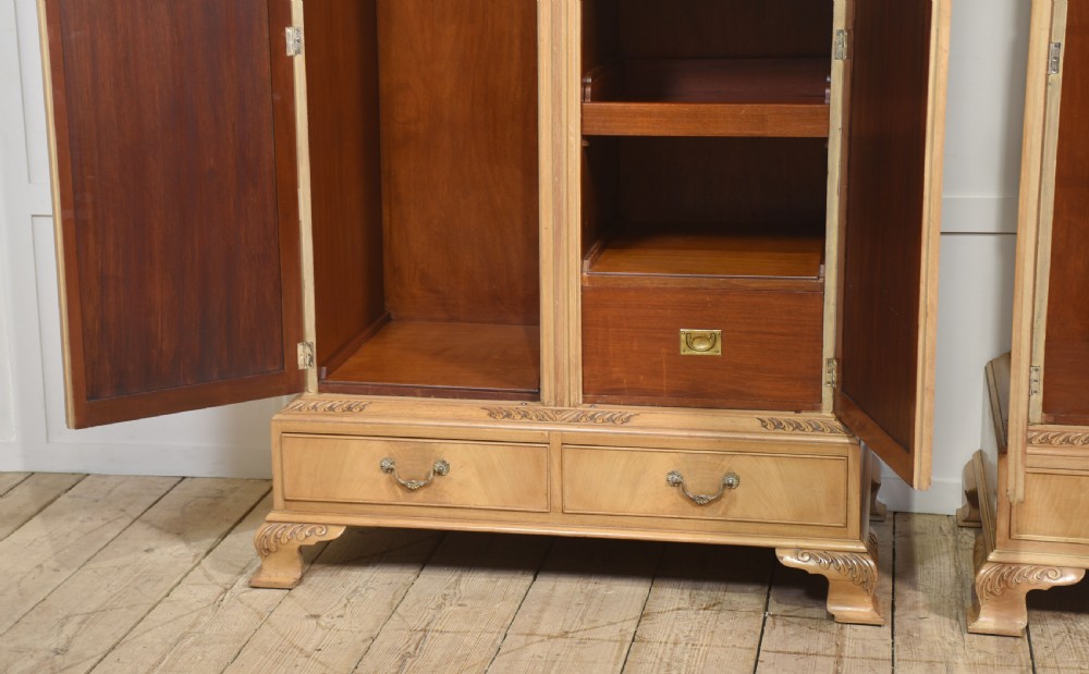 A near pair of tall light walnut wardrobes featuring twin arched mirrored doors, rope-twist carved borders, shell motifs, and two base drawers on carved feet. View XI