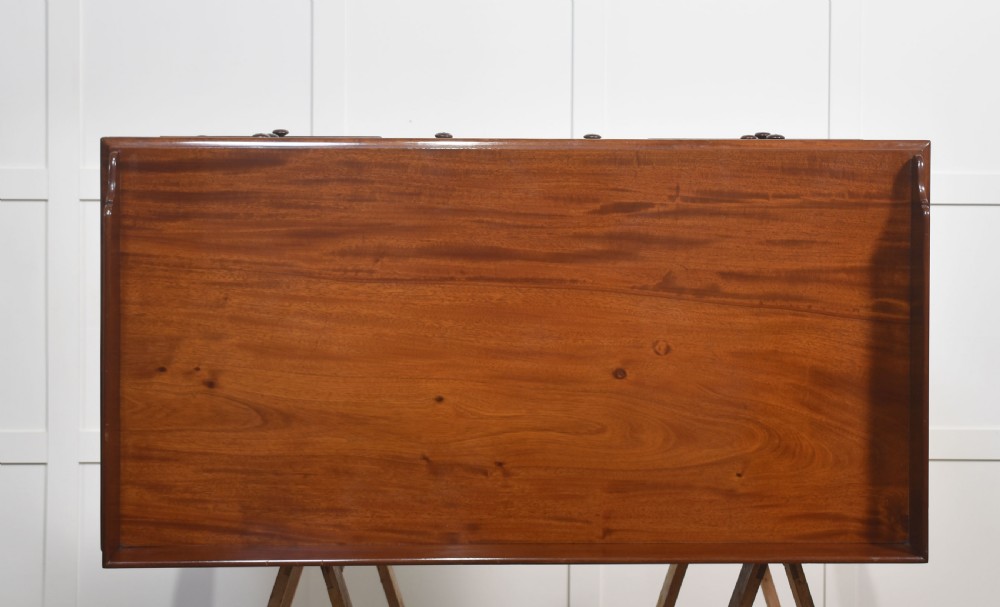 A 19th-century mahogany writing desk featuring seven drawers with dark wooden knobs, a low gallery back, turned legs, and brass castors. View XIV
