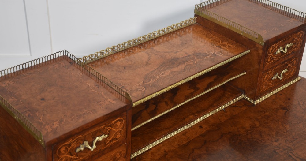 A 19th-century French writing desk crafted from figured walnut wood featuring gilt-bronze ormolu mounts, cabriole legs, floral marquetry drawer fronts, and an upper superstructure with pigeonholes. View VIII