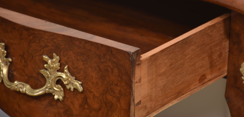 A 19th-century French writing desk crafted from figured walnut wood featuring gilt-bronze ormolu mounts, cabriole legs, floral marquetry drawer fronts, and an upper superstructure with pigeonholes. View XIV