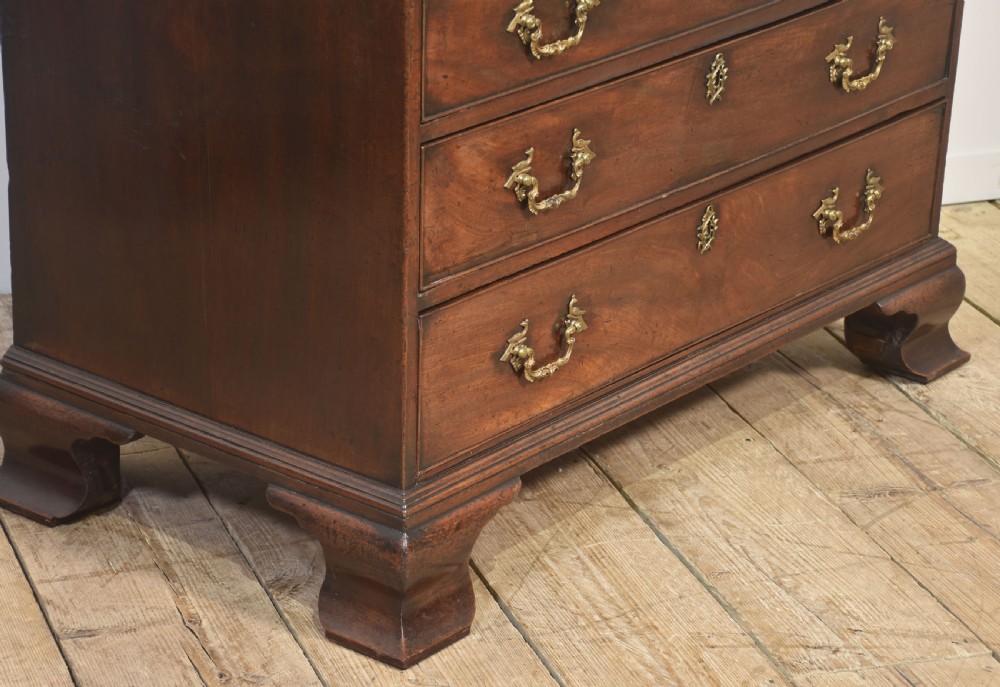 A George III mahogany bureau featuring a sloping fall-front lid above four graduated drawers with brass handles and bracket feet. View IX