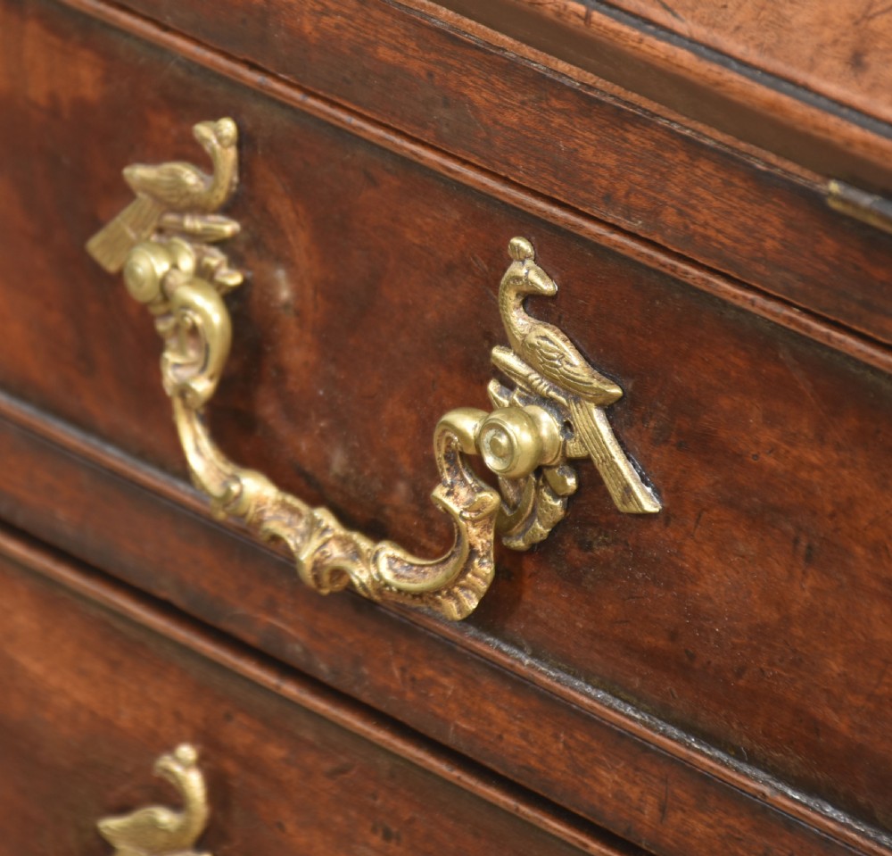 A George III mahogany bureau featuring a sloping fall-front lid above four graduated drawers with brass handles and bracket feet. View XV