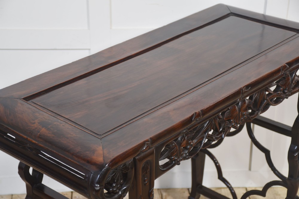 A dark hardwood Chinese altar table featuring openwork carved aprons, everted flanges, and decorative carved stretchers. View II