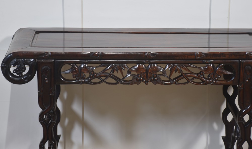 A dark hardwood Chinese altar table featuring openwork carved aprons, everted flanges, and decorative carved stretchers. View VII