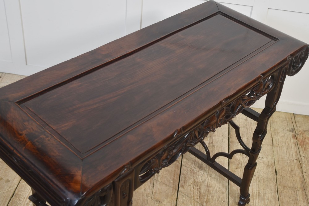 A dark hardwood Chinese altar table featuring openwork carved aprons, everted flanges, and decorative carved stretchers. View X