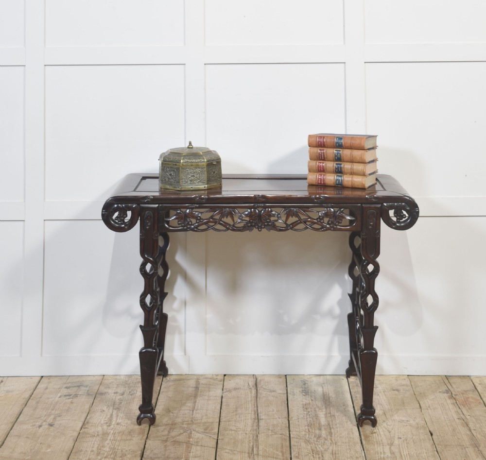 A dark hardwood Chinese altar table featuring openwork carved aprons, everted flanges, and decorative carved stretchers. View XIII