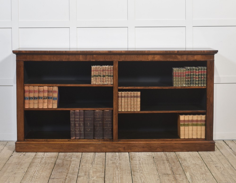 A nineteenth-century low rosewood open bookcase featuring two wide bays with adjustable horizontal shelves and a simple plinth base.