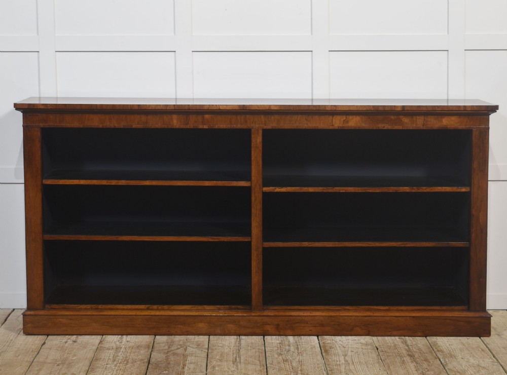 A nineteenth-century low rosewood open bookcase featuring two wide bays with adjustable horizontal shelves and a simple plinth base. View VIII