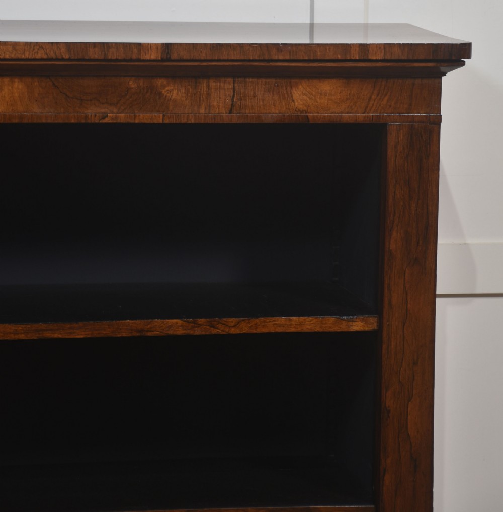 A nineteenth-century low rosewood open bookcase featuring two wide bays with adjustable horizontal shelves and a simple plinth base. View X