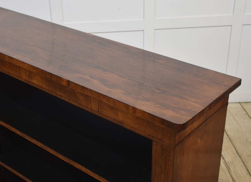 A nineteenth-century low rosewood open bookcase featuring two wide bays with adjustable horizontal shelves and a simple plinth base. View XIII