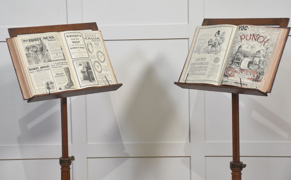 A pair of adjustable oak music stands featuring slatted wooden rests, fluted central columns, brass adjustment collars, and tripod bases. View XI