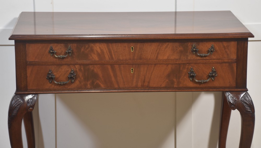 A polished mahogany cutlery chest table featuring two drawers with brass handles, raised on carved cabriole legs with ball and claw feet. View VI