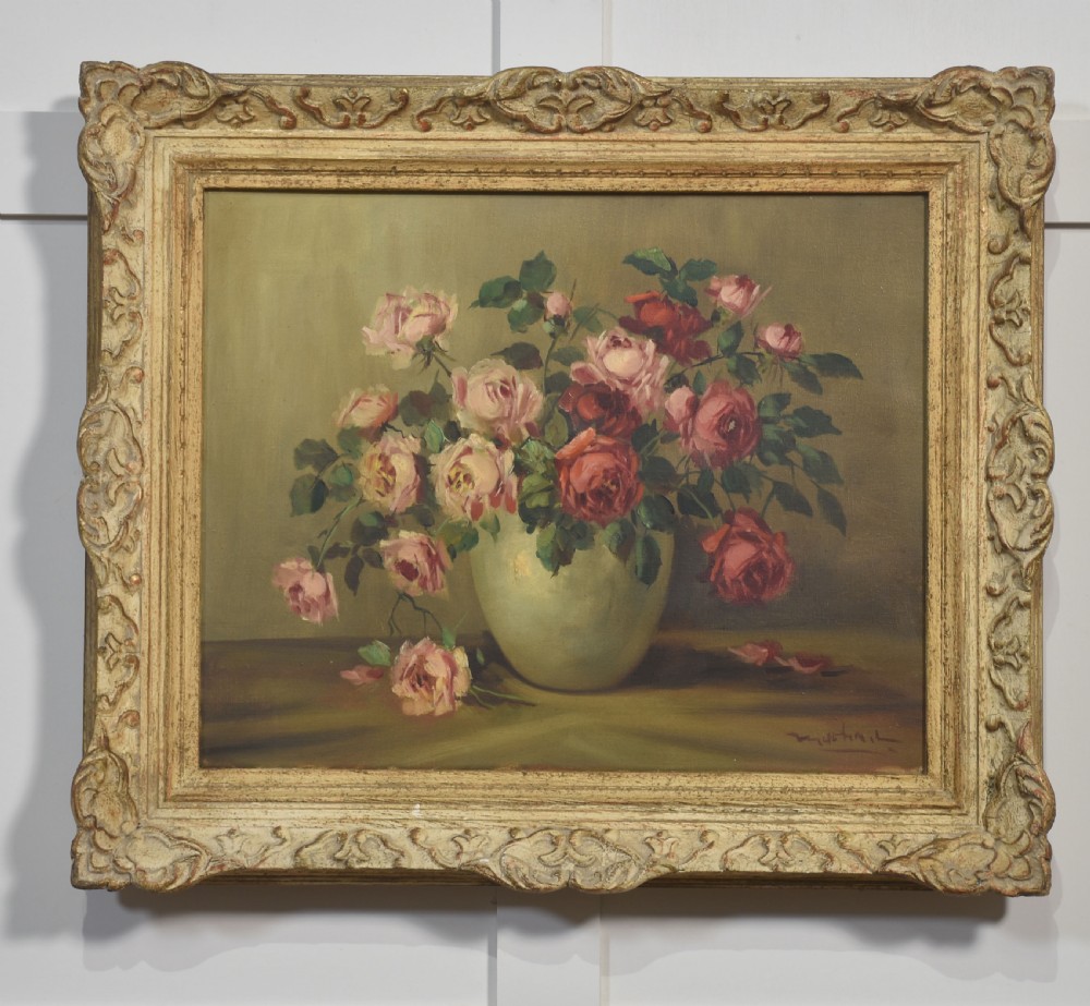 An antique framed oil painting depicting pink and red roses arranged in a light ceramic vase against a muted olive green background.