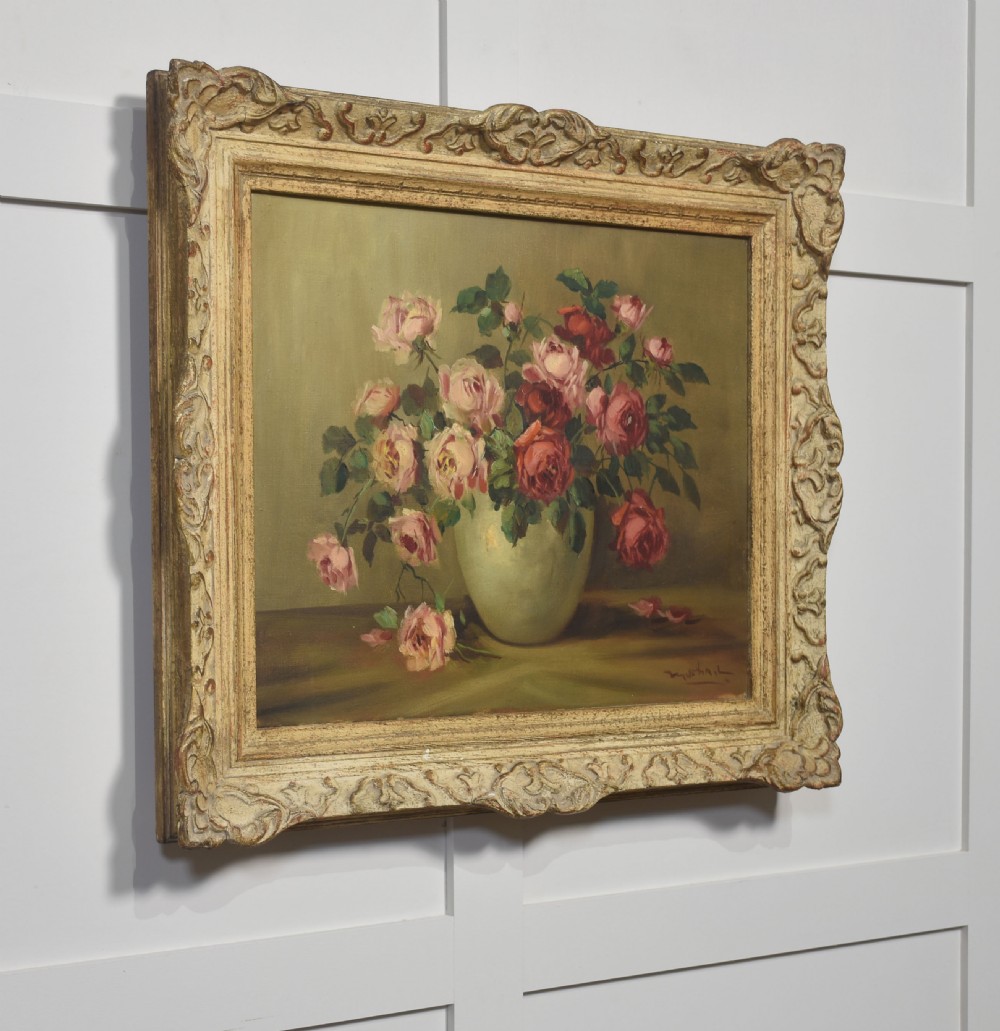 An antique framed oil painting depicting pink and red roses arranged in a light ceramic vase against a muted olive green background. View III