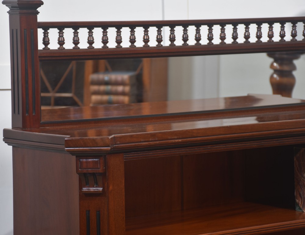 A Victorian mahogany open bookcase featuring four open shelves, fluted side columns, and a upper mirrored back with a turned spindle gallery. View VII