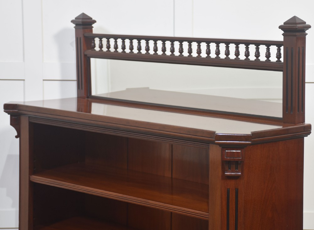 A Victorian mahogany open bookcase featuring four open shelves, fluted side columns, and a upper mirrored back with a turned spindle gallery. View XIII