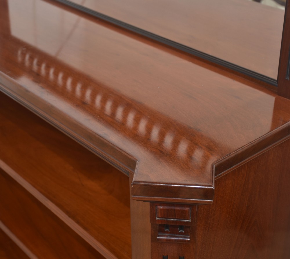 A Victorian mahogany open bookcase featuring four open shelves, fluted side columns, and a upper mirrored back with a turned spindle gallery. View XIV