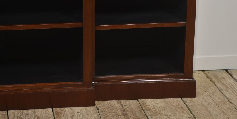 A wide mahogany open breakfront bookcase with four tiers of shelving containing antique leather-bound books. View XI