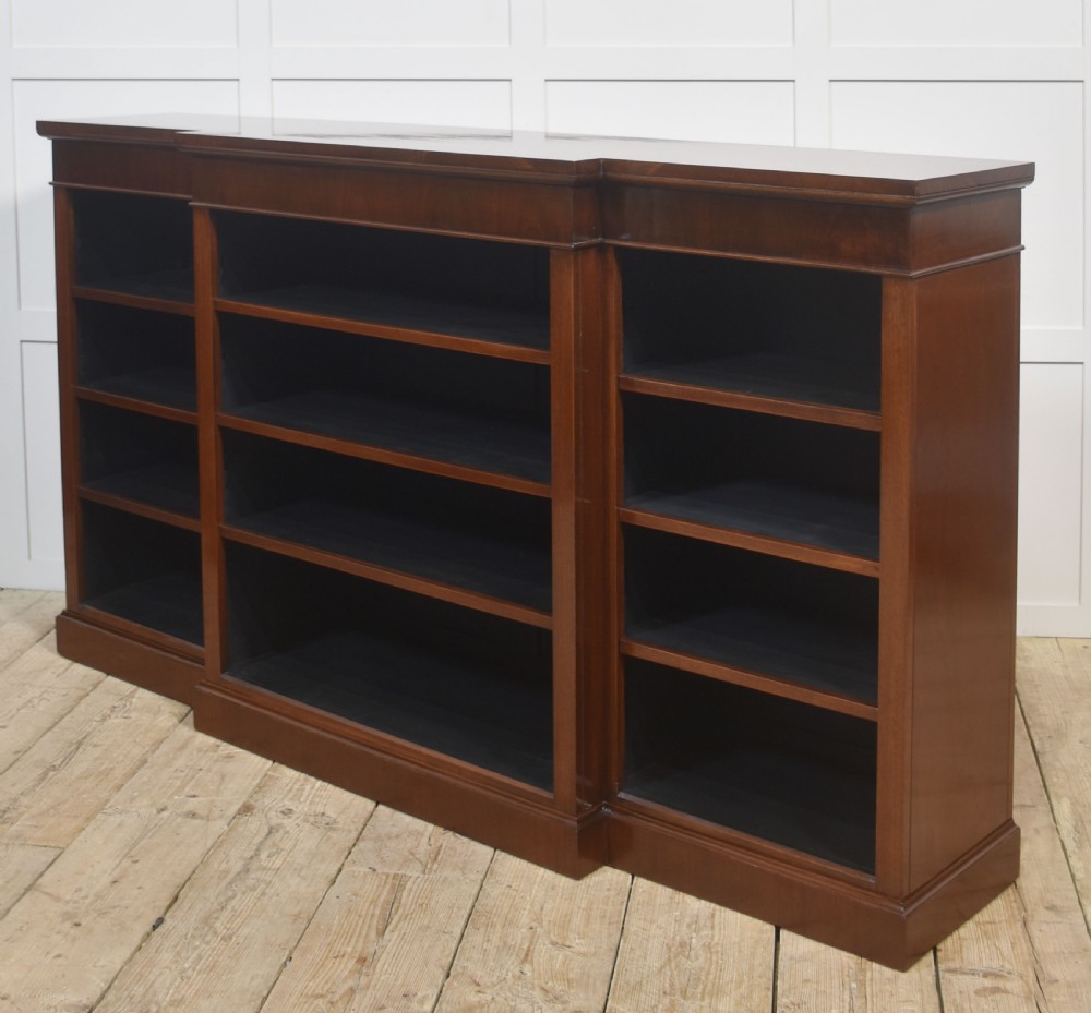 A wide mahogany open breakfront bookcase with four tiers of shelving containing antique leather-bound books. View XIII