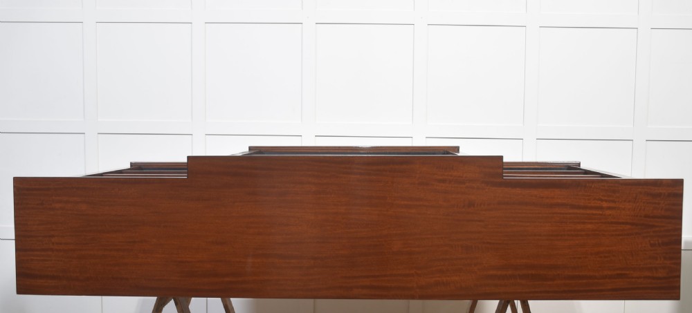 A wide mahogany open breakfront bookcase with four tiers of shelving containing antique leather-bound books. View XVI