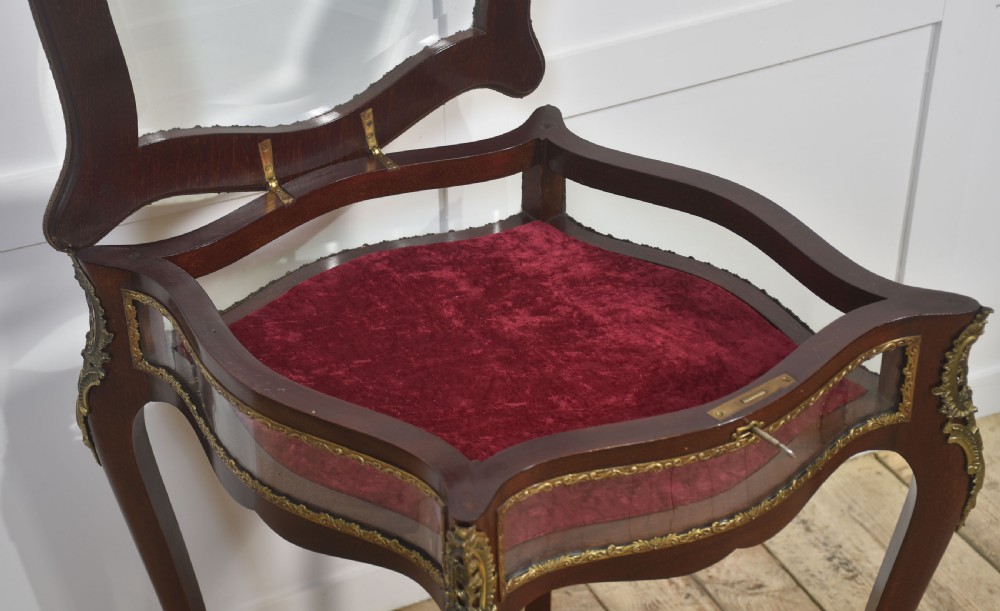 A mahogany bijouterie table featuring glass top and side panels, red velvet interior lining, brass mounts, and cabriole legs. View VIII