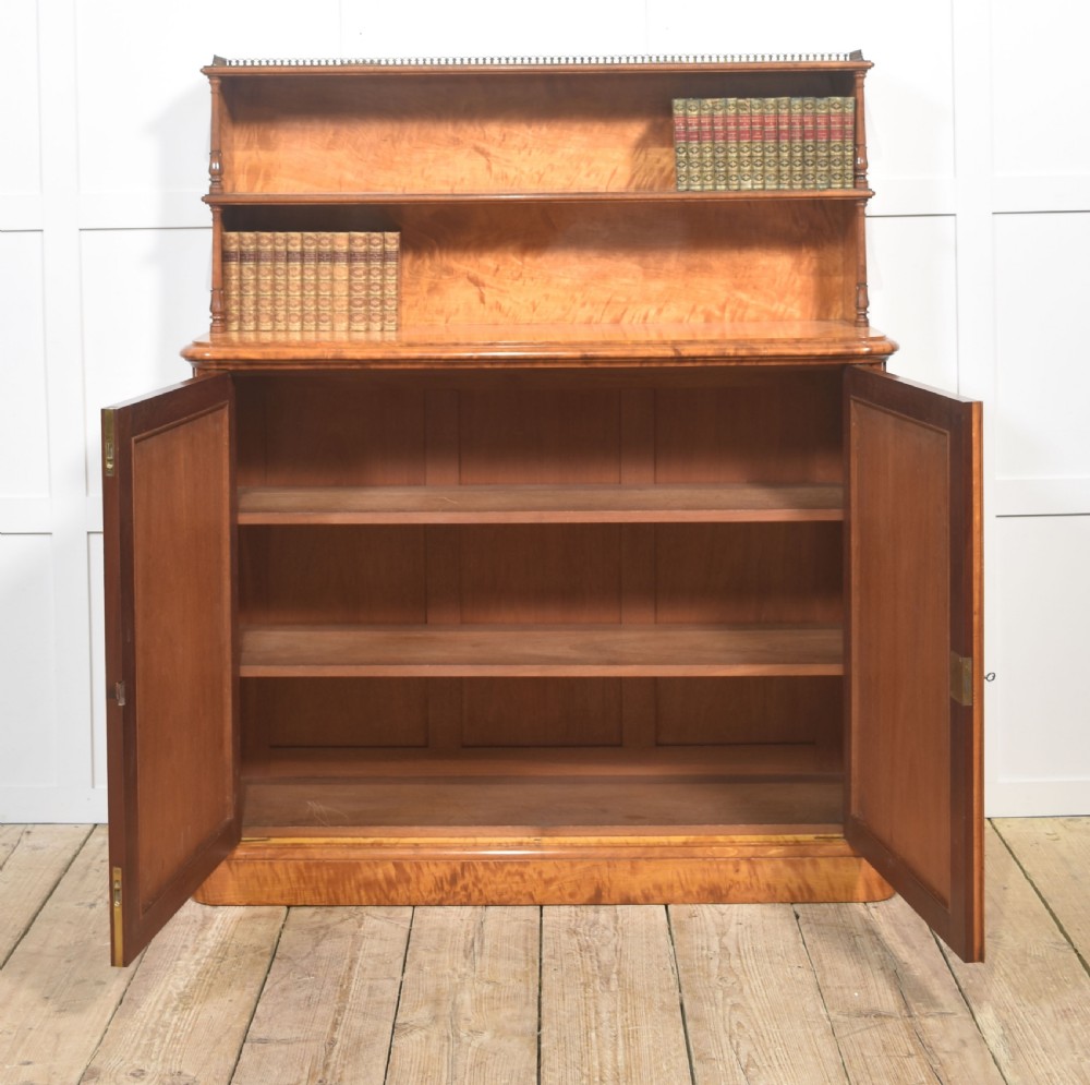 A William IV golden wood chiffonier featuring two open upper shelves with turned supports above a double-door cabinet with pleated fabric panels. View V