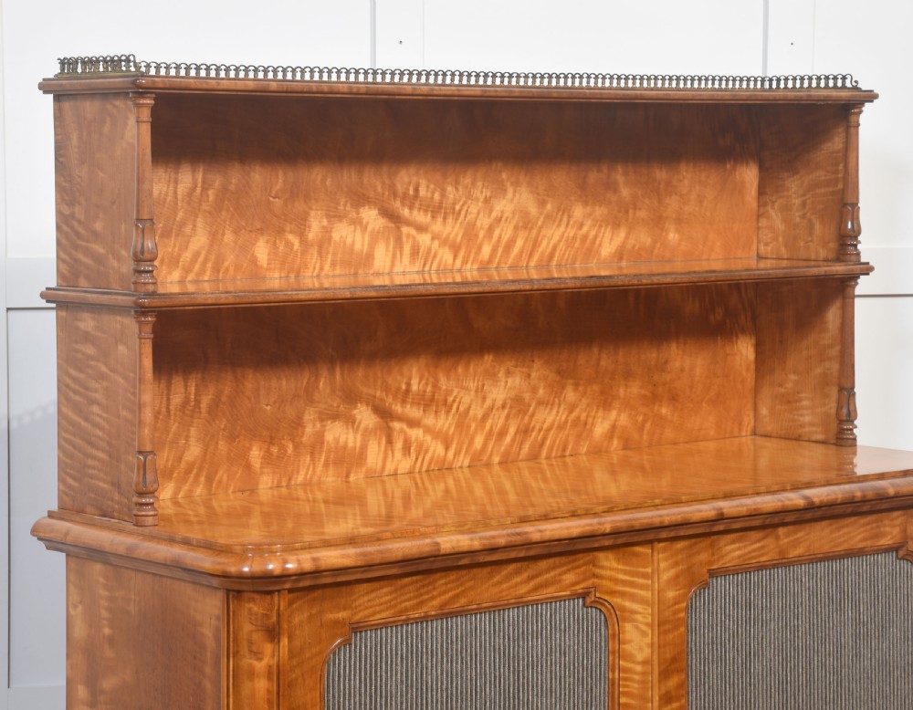 A William IV golden wood chiffonier featuring two open upper shelves with turned supports above a double-door cabinet with pleated fabric panels. View VI