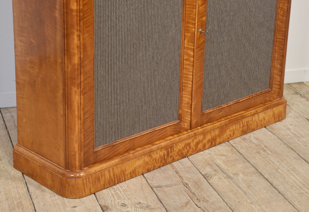 A William IV golden wood chiffonier featuring two open upper shelves with turned supports above a double-door cabinet with pleated fabric panels. View VII