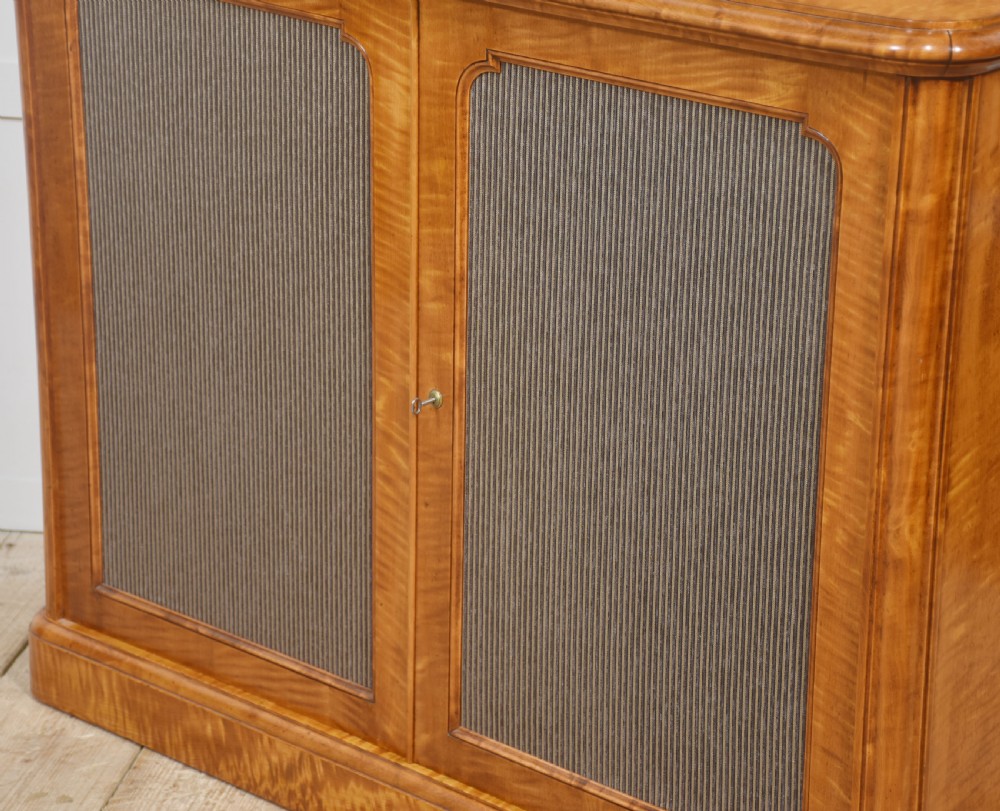 A William IV golden wood chiffonier featuring two open upper shelves with turned supports above a double-door cabinet with pleated fabric panels. View XII
